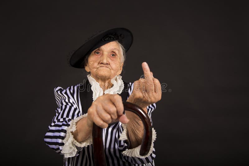 Παλαιό grandma σε ένα άσπρος-μαύρο ριγωτό σακάκι στοκ εικόνες